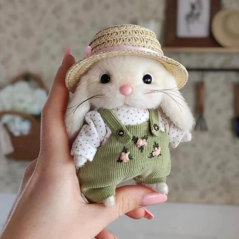 Peluche lapin jardinier debout dans la main d'une fille Image