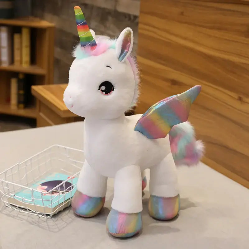 Peluche licorne blanche arc-en-ciel sur un lit