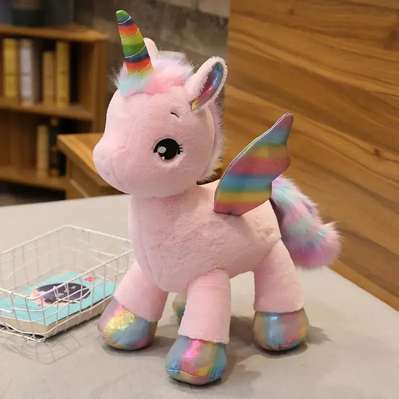 Peluche licorne rose arc-en-ciel sur un lit