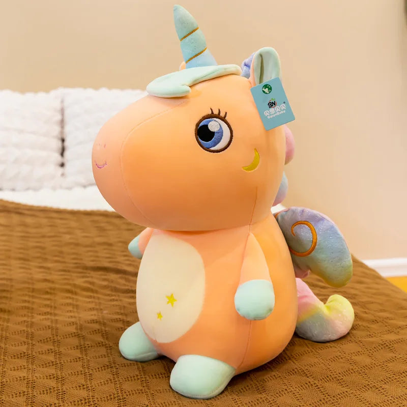 Peluche licorne orange assise sur un lit