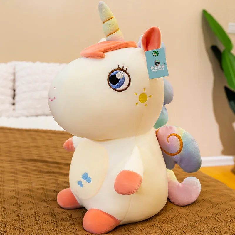 Peluche licorne blanche assise sur un lit