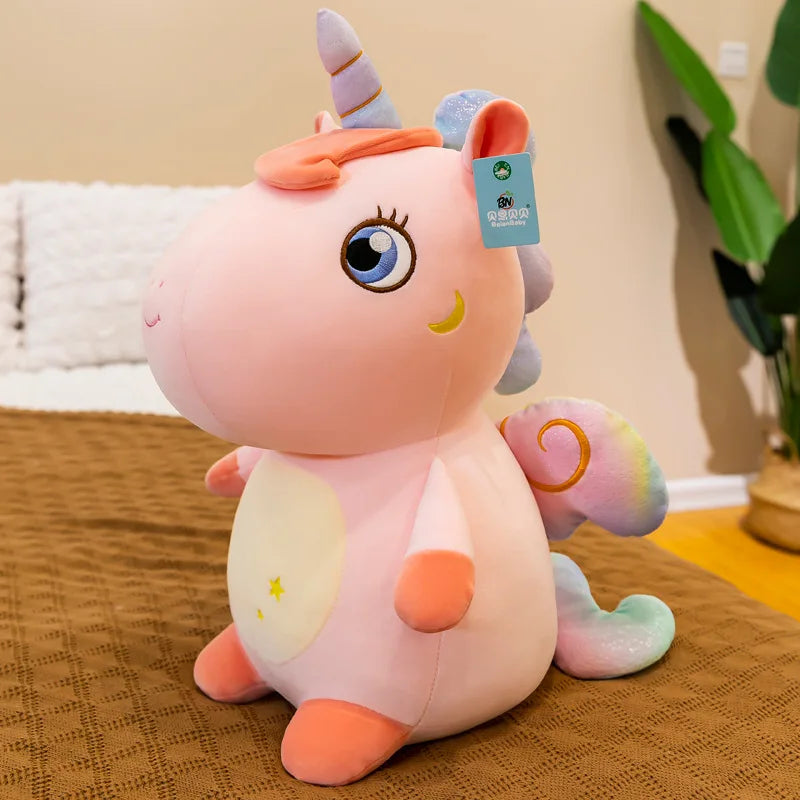 Peluche licorne rose assise sur un lit