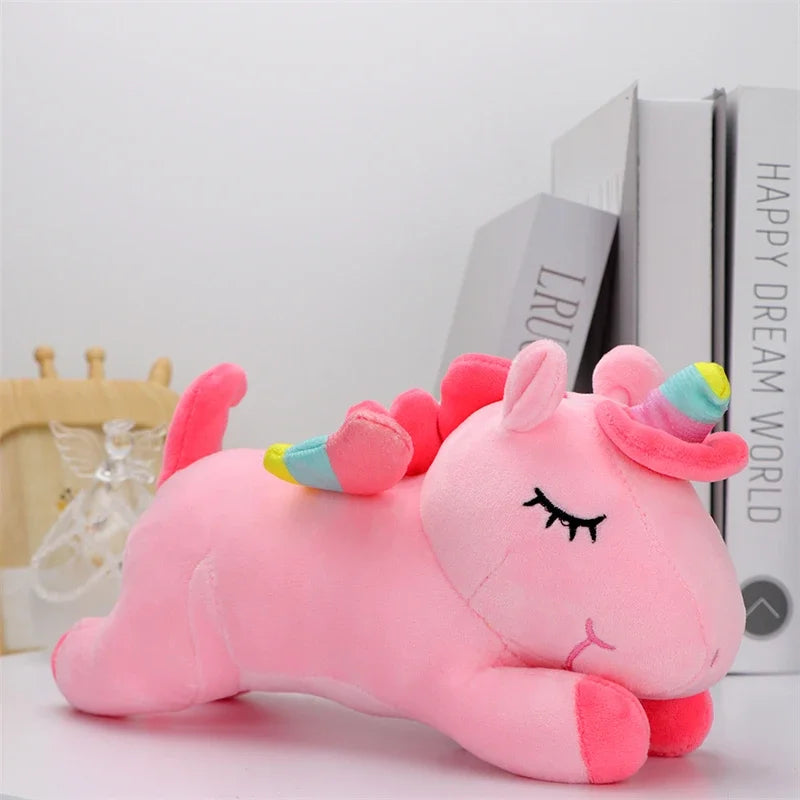 Peluche licorne rose endormi sur une table