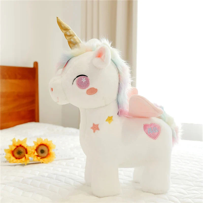Peluche licorne rose fantaisie sur un lit 