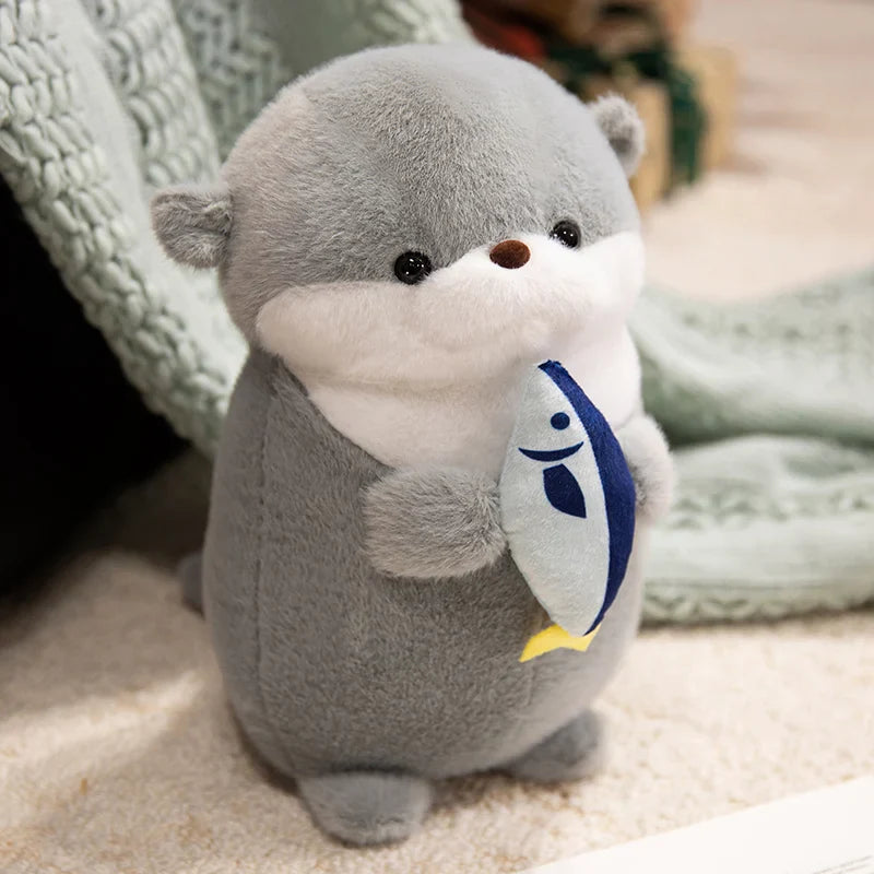 Peluche loutre grise avec son poisson sur un tapis
