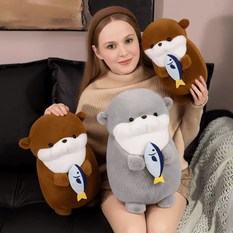 Trois peluches loutres avec leurs poissons sur les genoux d'une fille Image