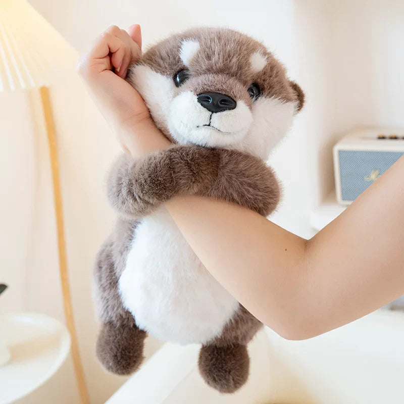 Peluche loutre à câliner accrocher sur le bras d'une fille