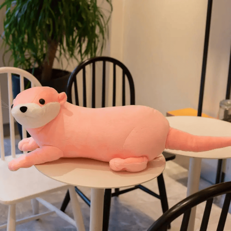 Peluche loutre rose sur une table
