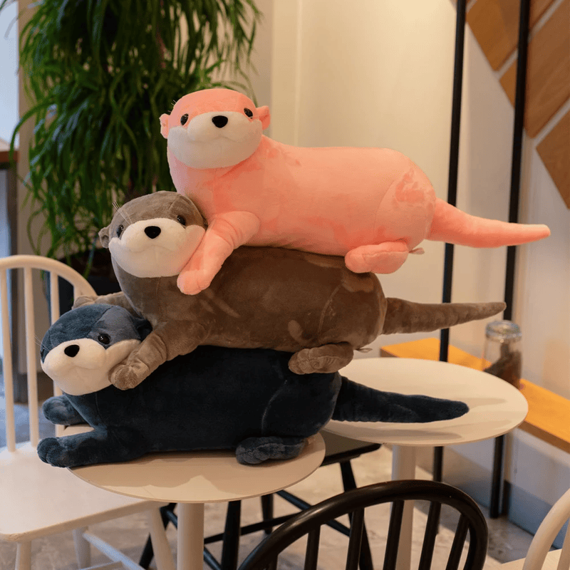 Trois peluches de loutres colorées sur une table Image