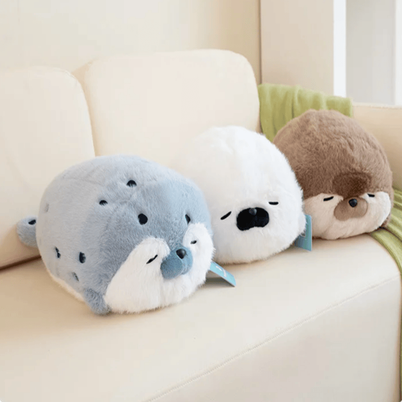 Trois peluches loutres de mer sur un canapé Image