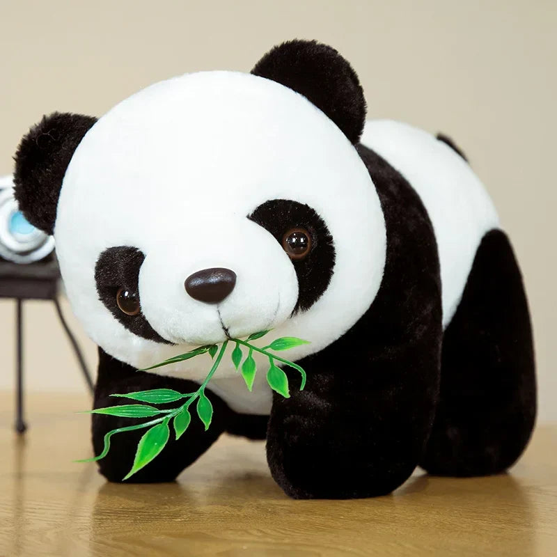 Peluche panda sur un parquet avec ses feuilles de bambou Image
