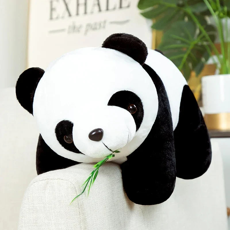 Peluche panda avec ses feuilles de bambou sur un canapé