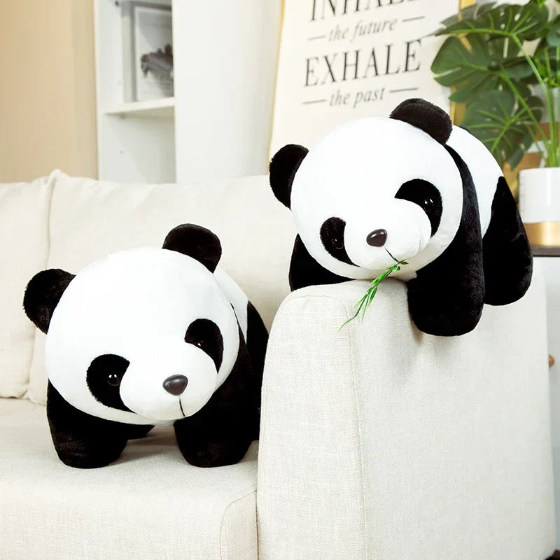 Deux peluches panda avec ses feuilles de bambou sur un canapé