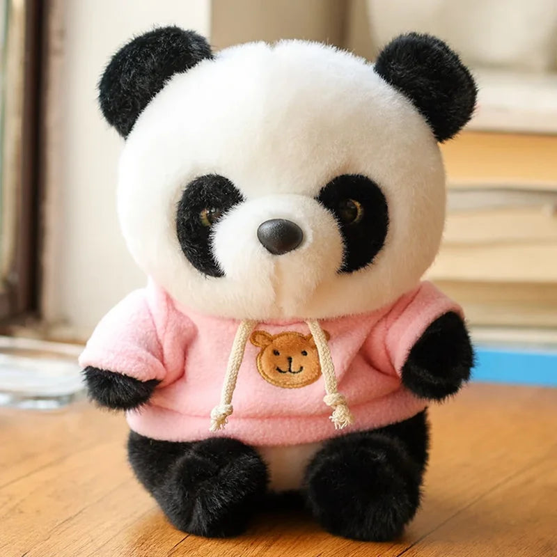 Peluche panda avec son pull rose sur un bureau Image