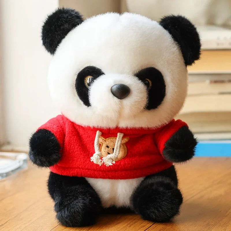 Peluche panda avec son pull rouge sur un bureau Image