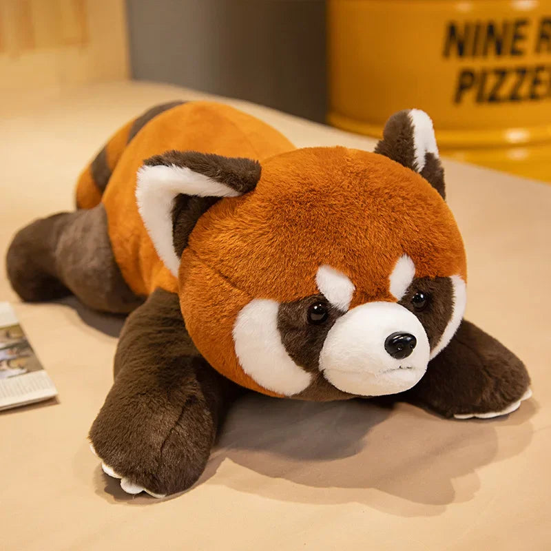 Peluche coucher de panda roux sur une table