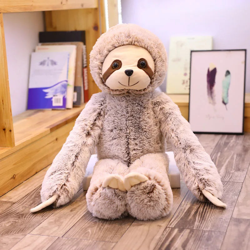 Peluche paresseux douce assis sur un parquet devant une bibliothèque