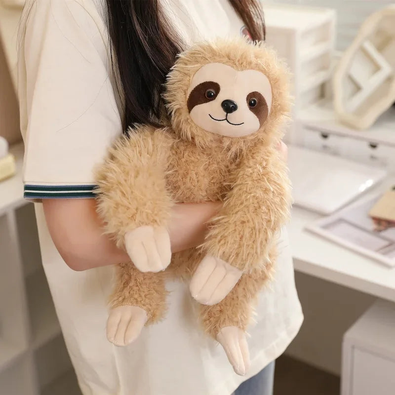 Peluche paresseux beige heureux dans le bras d'une fille