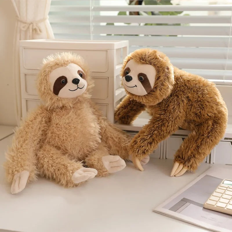 Deux peluches paresseux heureux sur un meuble