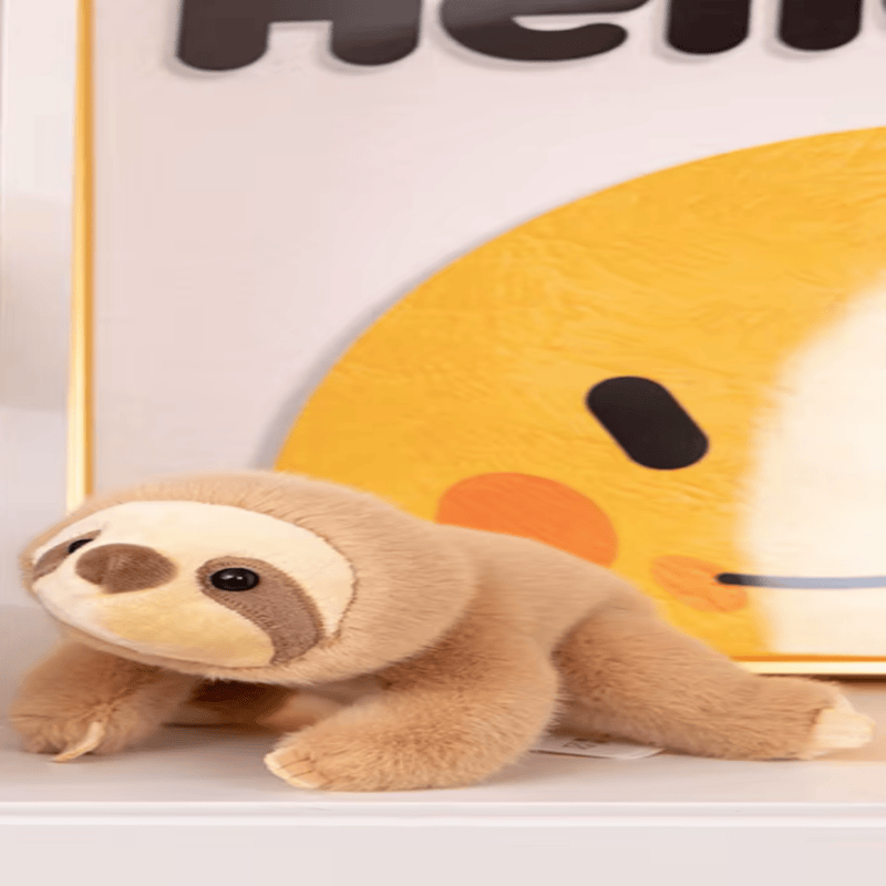Peluche paresseux kawaii sur une bibliothèque 