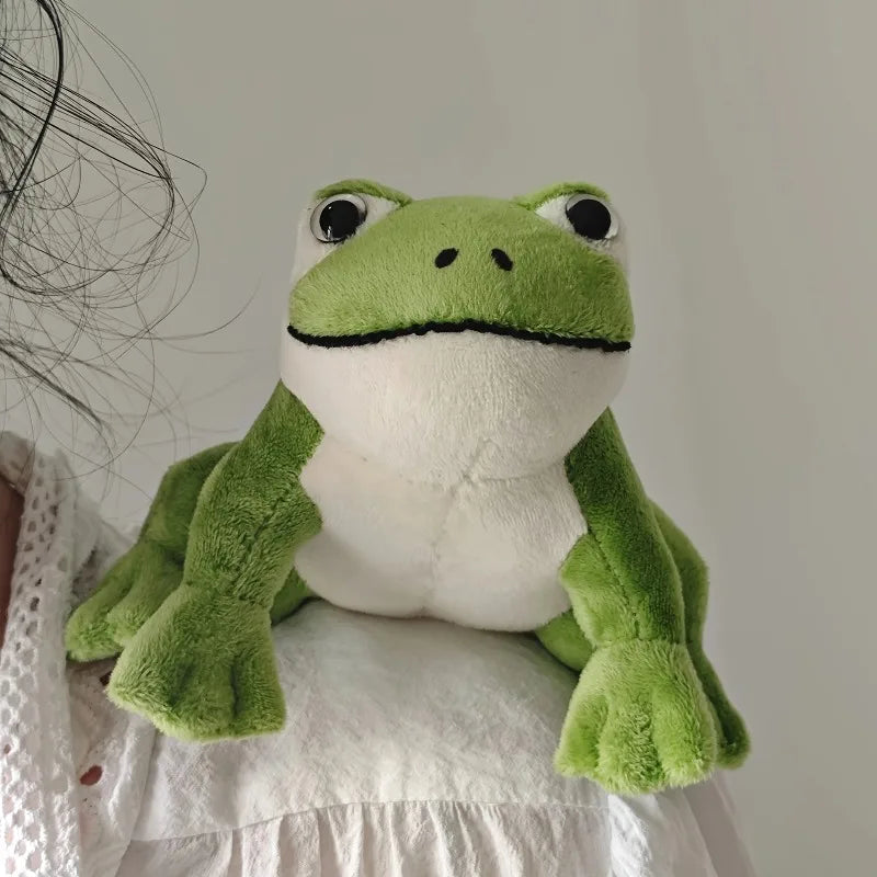 Peluche petite grenouille sur l'épaule d'une femme 