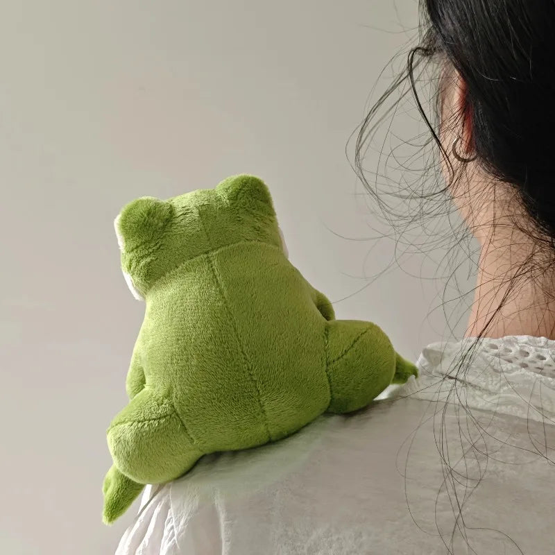 Peluche petite grenouille sur l'épaule d'une femme de dos Image