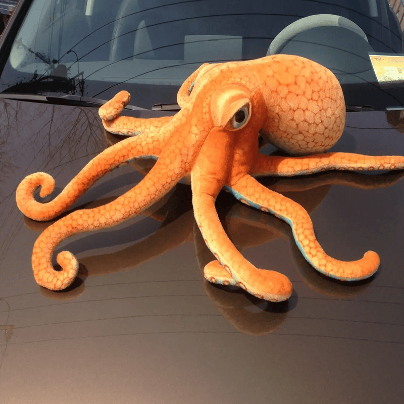 Peluche pieuvre réaliste sur le capot d'une voiture