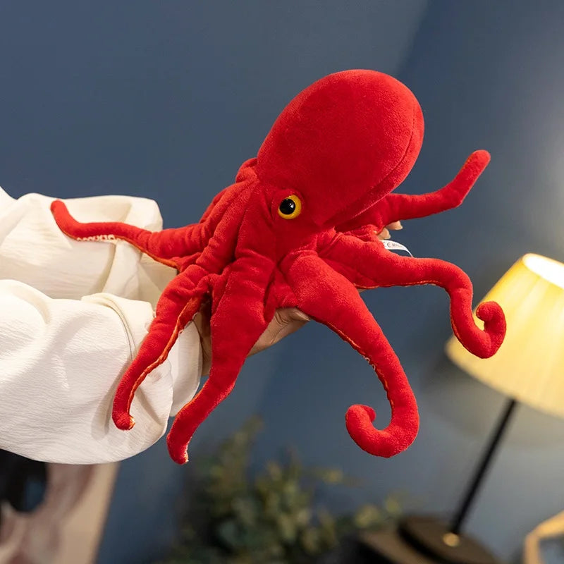 Peluche pieuvre rouge dans la main d'une fille