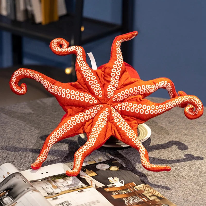 Peluche pieuvre rouge vue du dessous sur une table