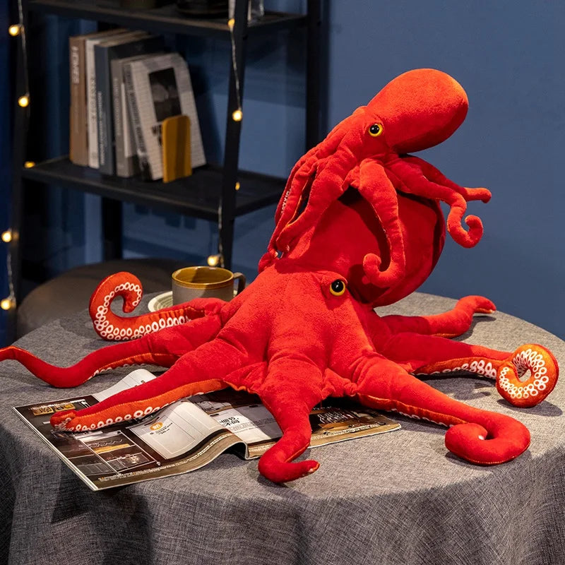 Deux peluches pieuvres rouges l'une sur l'autre sur une table