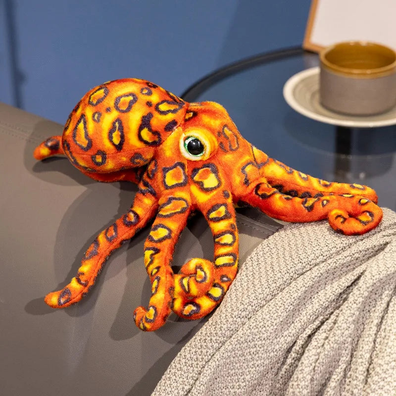 Peluche pieuvre tacheté orange sur un canapé