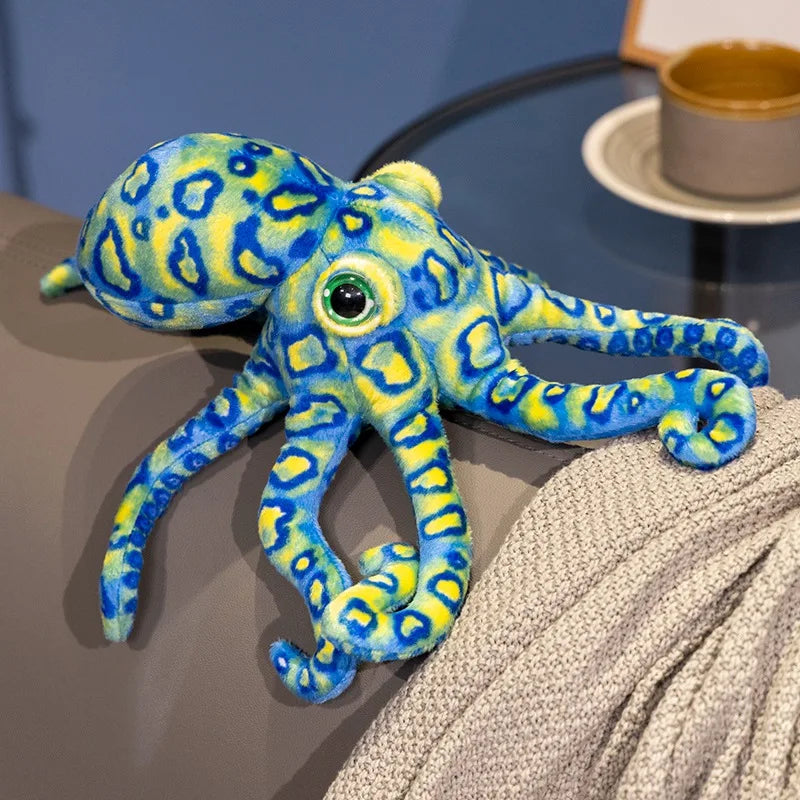 Peluche pieuvre tacheté bleue sur un canapé