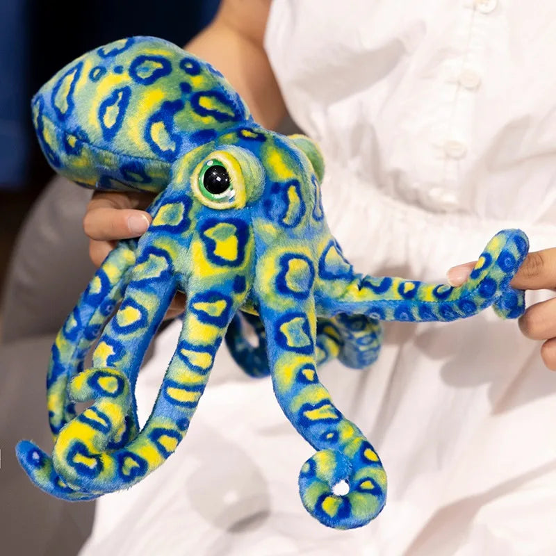 Peluche pieuvre tacheté bleue dans les mains d'une fille