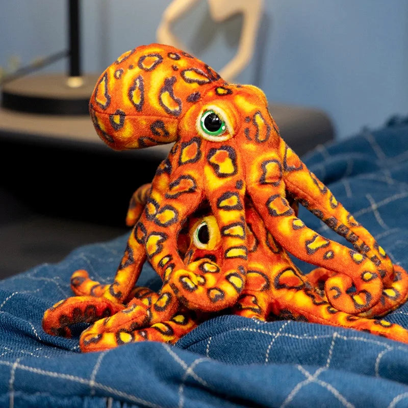 Deux peluches pieuvres tachetés orange sur un drap Image