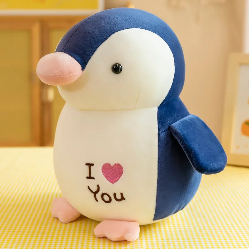 Peluche pingouin bleu I love you sur une table avec une nappe à carreaux jaune et blanc Image
