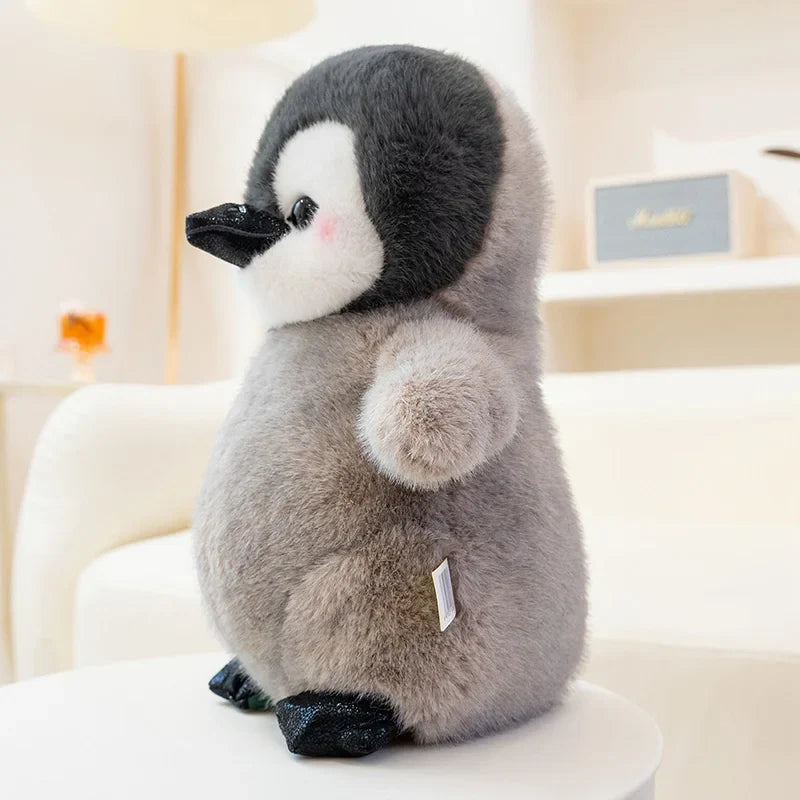 Peluche pingouin antarctique assis de profil sur un fauteuil