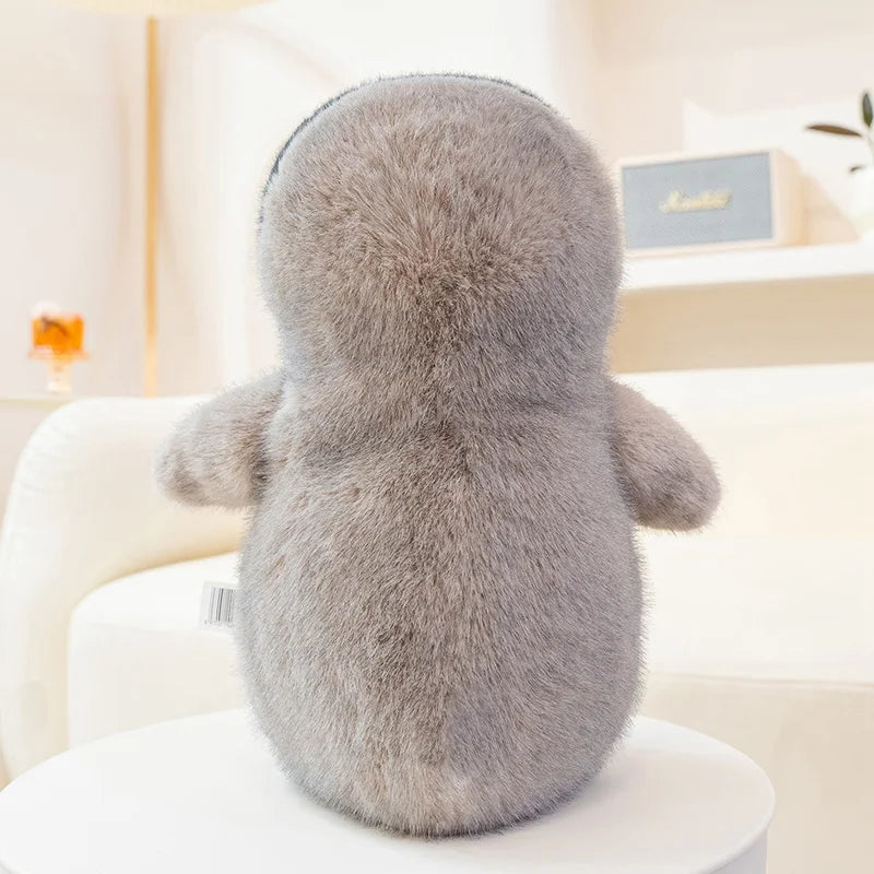 Peluche pingouin antarctique assis de dos sur un fauteuil