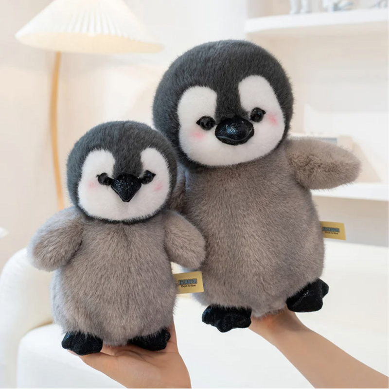 Deux peluches pingouins antarctique dans les mains d'une fille