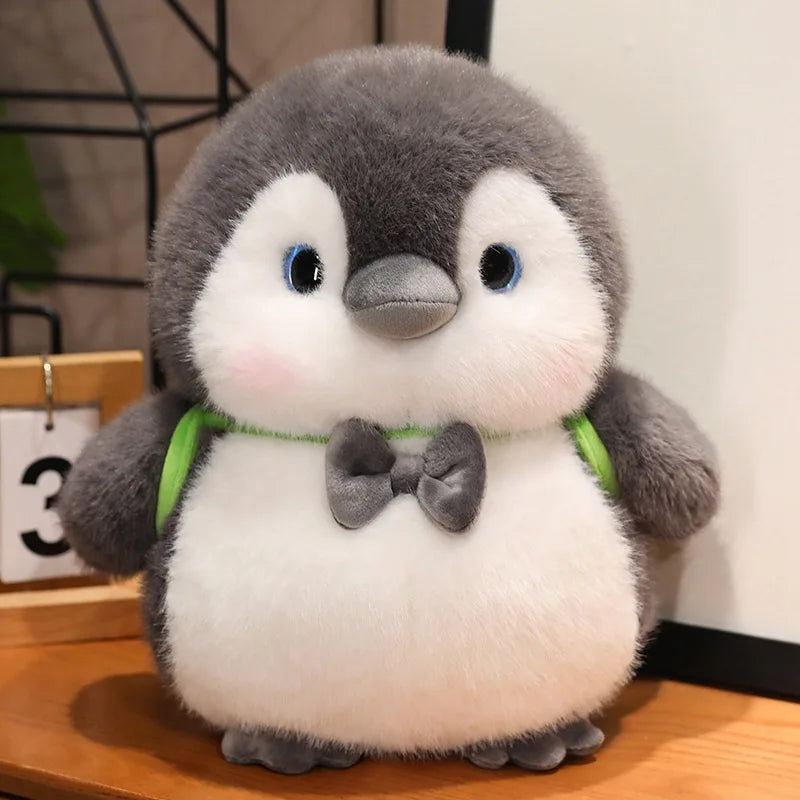 Peluche pingouin avec un sac à dos vert sur une table