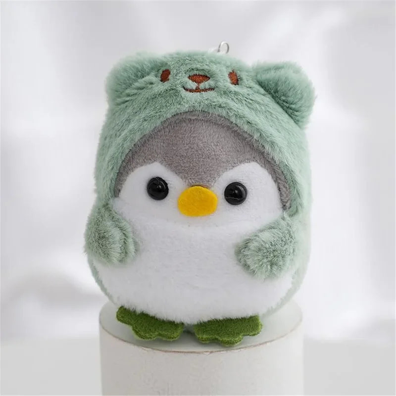 Peluche pingouin avec une capuche d'ours vert sur un bâtonnet
