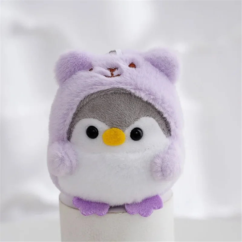 Peluche pingouin avec une capuche d'ours violet sur un bâtonnet