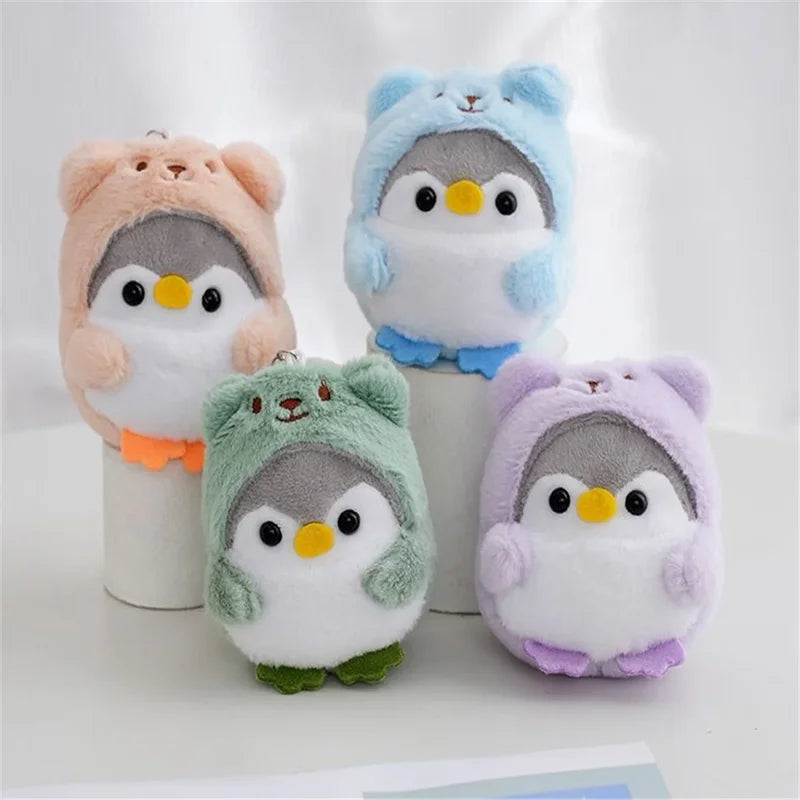 Quatre peluche pingouin avec une capuche d'ours sur une table Image