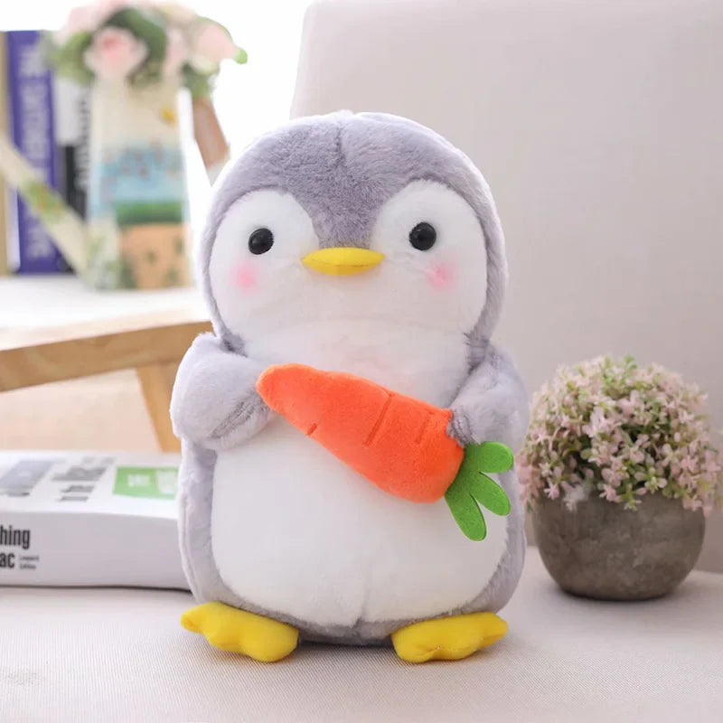 Peluche pingouin fruité avec une carotte sur une table