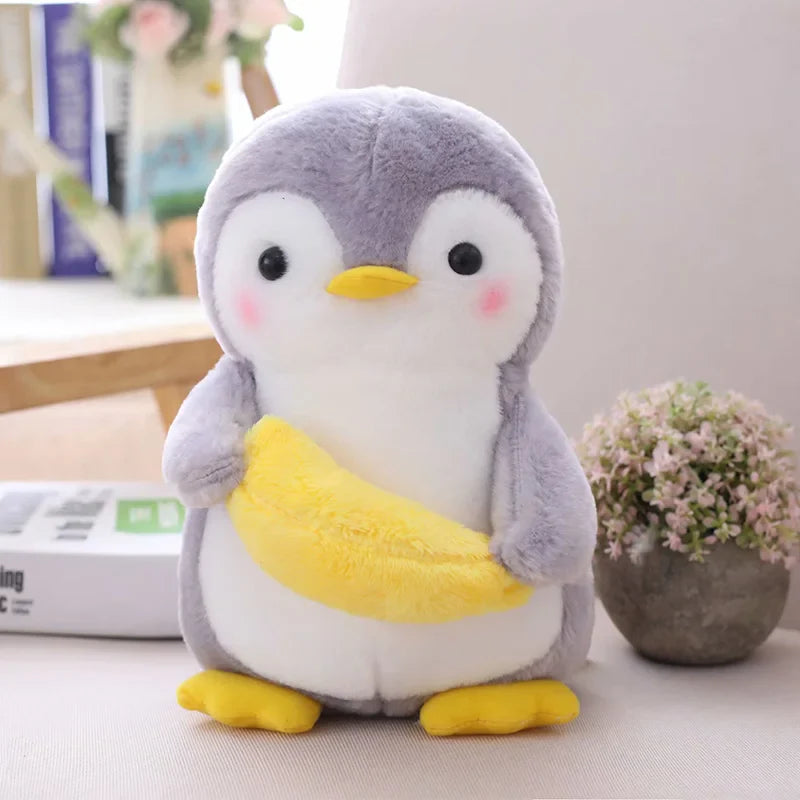 Peluche pingouin fruité avec une banane sur une table