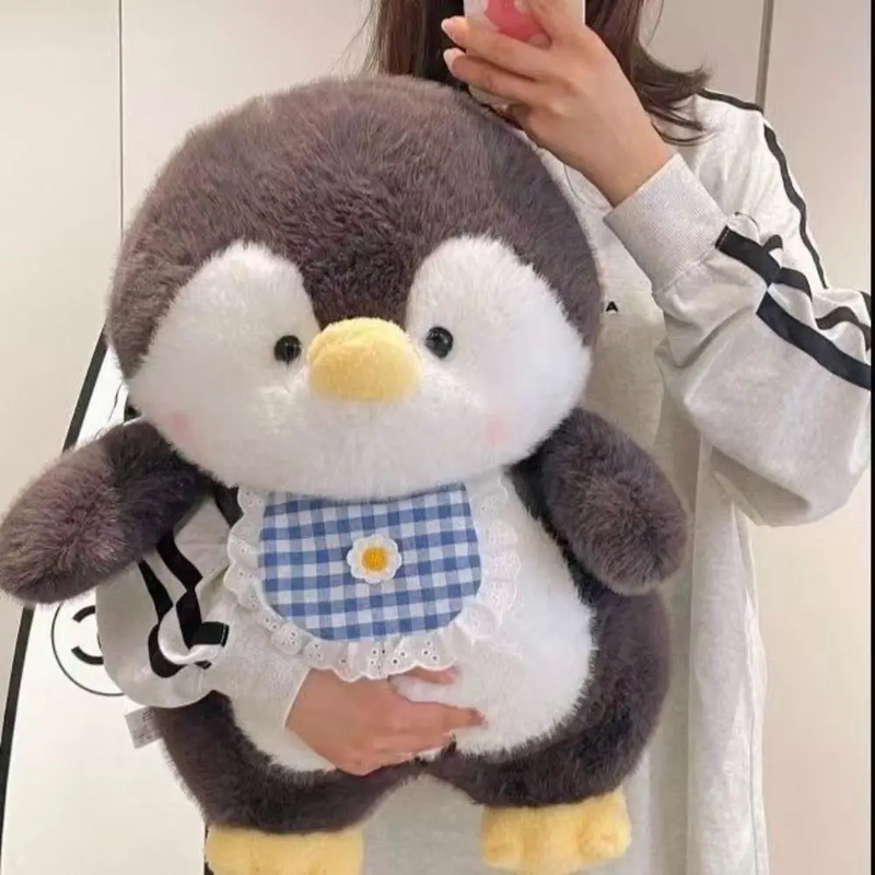Peluche pingouin kawaii dans les bras d'une fille