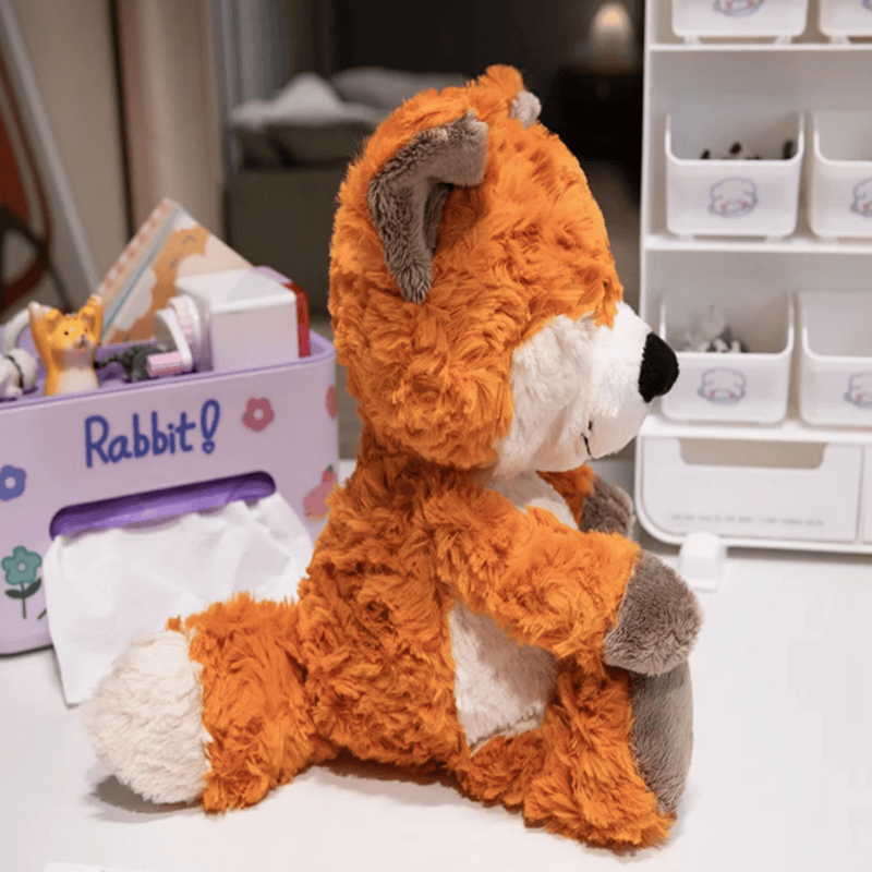 Peluche renard câlin de profil sur une table blanche