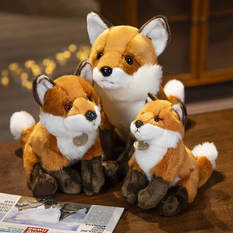 Trois peluches renards domestique sur une table en bois Image