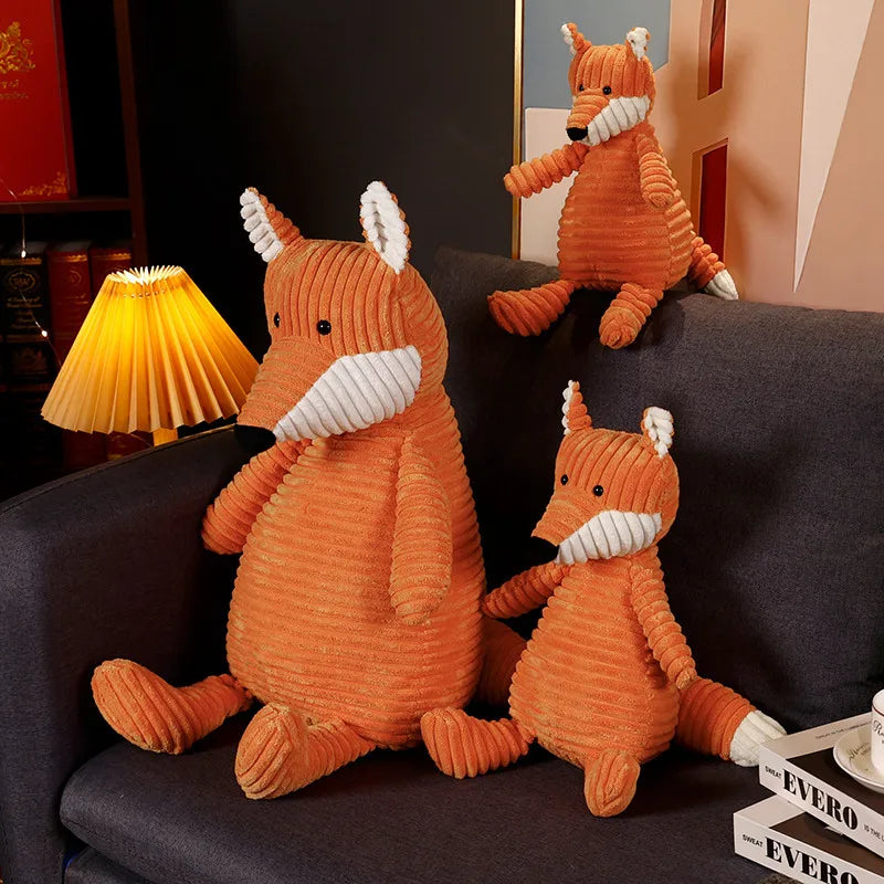 Trois peluches renard kawaii sur un canapé