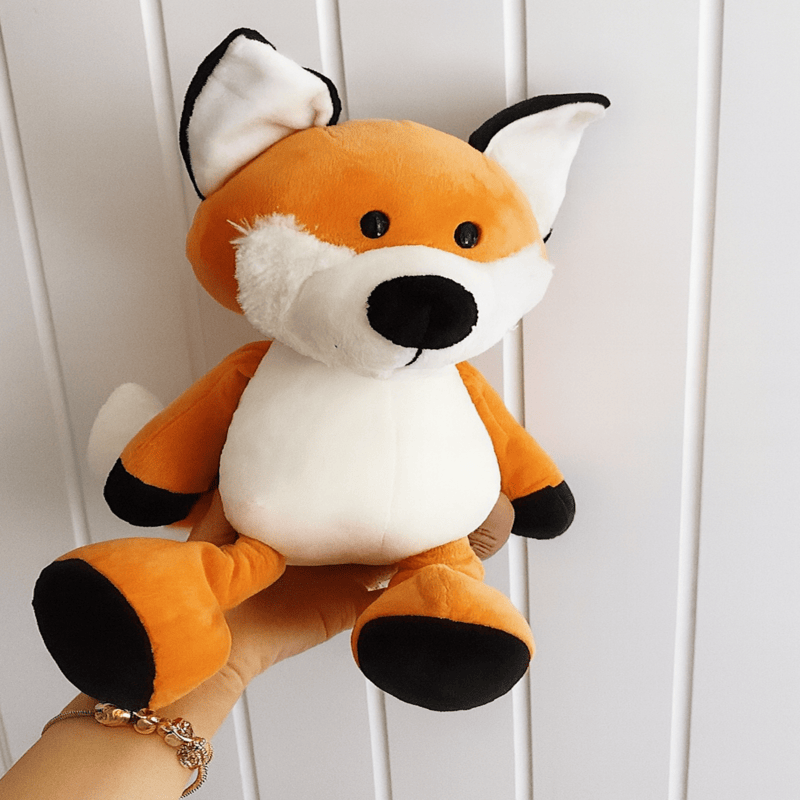 Peluche renard moelleuse tenue par une fille 