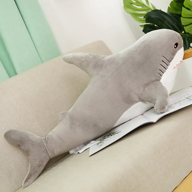 Peluche requin gris sur un canapé